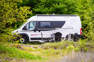 Camper van or motorhome is free camping on the side of the road on Buško lake, Bosnia and Herzegovina. Wild camping in Bosnia, Greece or Croatia in nature next to the lake.