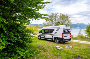 Camper van or motorhome is free camping on the side of the road on Buško lake, Bosnia and Herzegovina. Wild camping in Bosnia, Greece or Croatia in nature next to the lake.