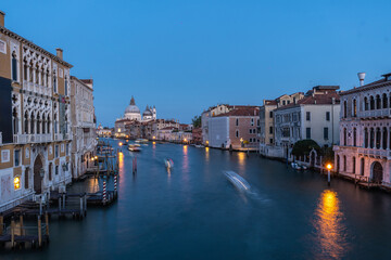 Motorboats navigating grand canal in venice at blue hour