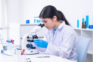 Teen girl adjusting microscope during laboratory experiment. Science, laboratory, scientist,...