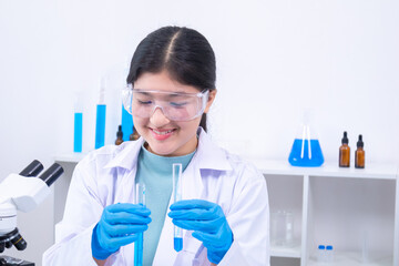 Scientist girl in lab coat observing chemical substance with care during experiment. Science,...