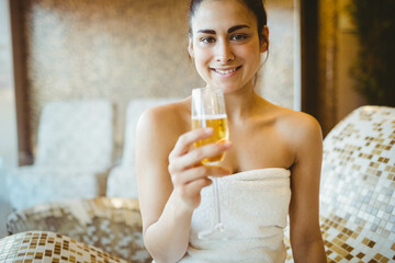 Champagne flute is resting on mosaic-tiled bench in spa lounge during warm ambient lighting © WavebreakMediaMicro