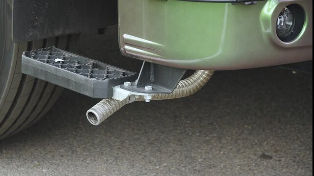 Exhaust pipe of truck with blue smoke coming out of it. Harmful emissions and crankcase gas removal in design of tractor. Environmental standards for motor transport and air pollution.