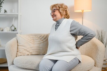 Senior woman suffering from back pain at home