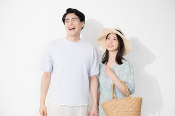 夏のカップルでお出かけやレジャーやリゾート旅行、新婚旅行や夏休みのイメージの全身手を繋ぐ 白背景