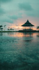 Obraz premium Blurred rain on a pond, pavilion at sunset