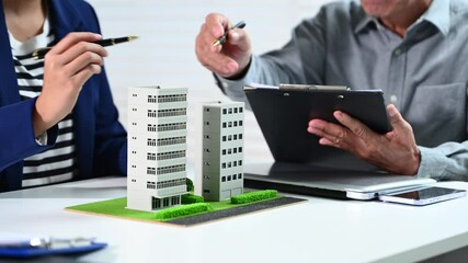 Real estate broker agent presenting and consult to customer to decision making sign insurance form agreement, condo model,