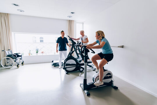 Patients exercising with physiotherapists in rehabilitation center gym