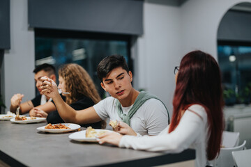 A group of students having a meal in a school canteen while engaging in conversation. This captures the essence of student life and social interaction during break time.
