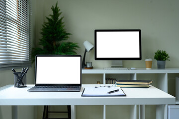 Fototapeta premium Contemporary office desk with empty computer displays and supplies