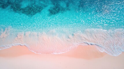 The blue and pink beach, with two or three small flowers dotting the picture. The background is the sparkling water, with thin strips of white foam, creating a bird's-eye view. The picture has soft to