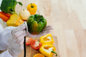 A gloved hand, resembling a doctor's, holds a tomato while using a stethoscope, symbolizing food...