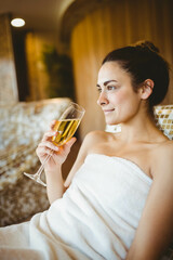 Champagne flute resting on lounge chair with white towel in spa room, with potted plant © WavebreakMediaMicro