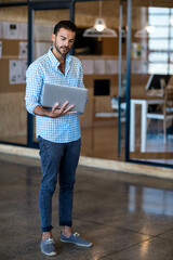 Silver laptop sitting on white desk in modern office lobby with glass partitions and pinned papers © WavebreakMediaMicro