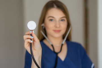 Medical professional presenting a stethoscope with focus on healthcare and compassion