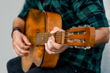 Playing an acoustic guitar. Guitarist hands and guitar. Man's hands playing acoustic guitar, close...