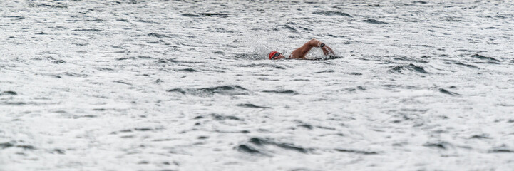 Ein Sportler schwimmt in einem See bei leichtem Wellengang