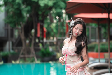 Elegant Young Woman in Floral Dress Posing Near Swimming Pool