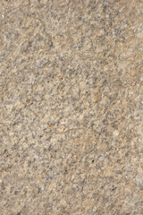 A close-up of a beige or light brown granite texture with darker specks