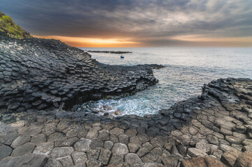 Da Dia reef or Ganh Da Dia in Phu Yen in Vietnam at sunrise. Landscape with volcanic basalt columns on rocky beach by the sea