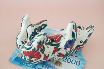 Ceramic toy cat and paper bills. Russian rubles.