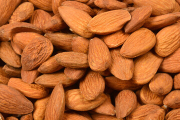 A close-up, top-down shot of a pile of raw almonds, showcasing their natural texture and color.