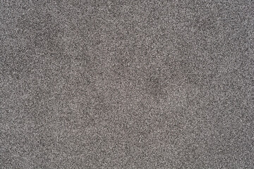 A close-up of an external facade texture, showing a granular, grey surface