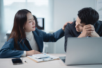 Asian businesspeople comforting each other after a bad news in office, businesswoman consoling sad...