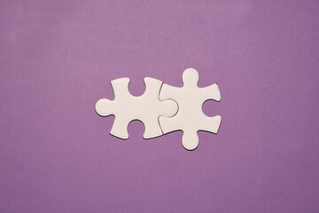 Dos piezas de puzzle blanca conectadas concepto de union sobre fondo morado,