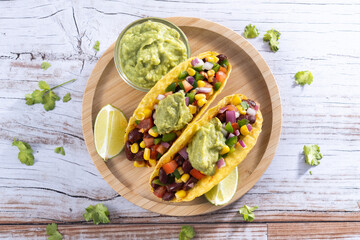 Vegan mexican Taco with beans and guacamole on wooden table