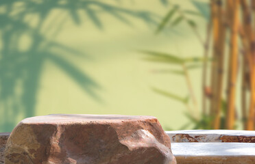 Rock stone podium step on blurred vintage garden background with bamboo tree shadow on green wall...