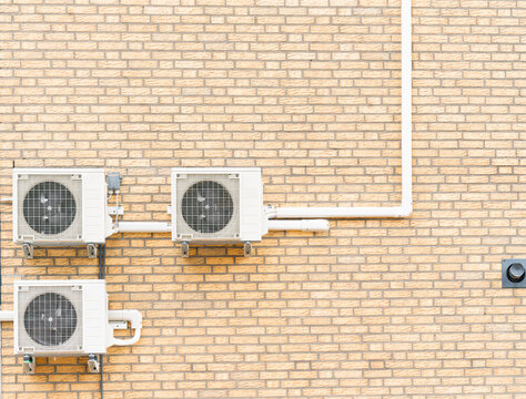 Three air conditioners on a house wall for cooling and heating
