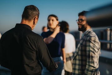 A diverse group of business colleagues engage in a brainstorming session on a balcony, under the...