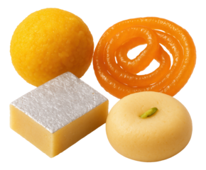 Assorted Indian sweets including a laddu, jalebi, barfi with silver foil, and a peda with a pistachio topping.