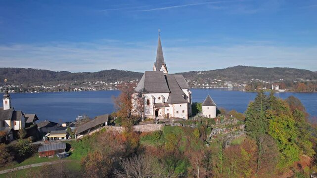 Flight over of Maria Worth church on Lake Worthersee, in Carinthia, Austria.
