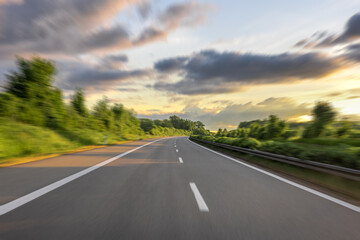 Naklejka premium Road motion blur. Fast drive on forest highway