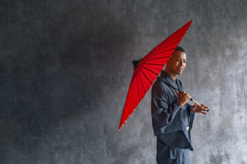 A black man wearing a Japanese yukata and holding a Japanese umbrella