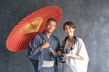A black man wearing a yukata being photographed by a photographer