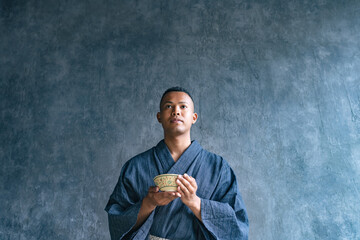 A black man wearing a yukata and experiencing a Japanese tea ceremony