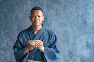 A black man wearing a yukata and experiencing a Japanese tea ceremony