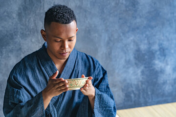A black man wearing a yukata and experiencing a Japanese tea ceremony