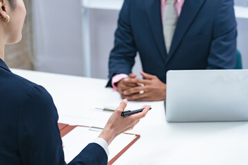 黒人男性ビジネスマンと面談する日本人女性スタッフ