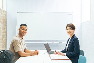 A black man and a Japanese female staff member having an interview