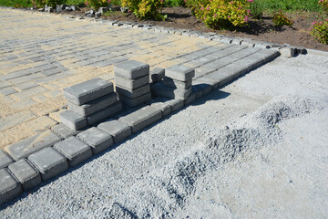 Patio pavement construction near the house. Laying paver bricks.