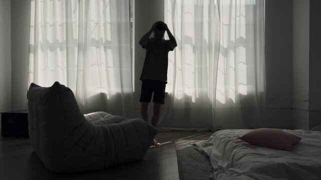 Man suffering from panic attack at home, walking back and forth in stress, struggling with anxiety.