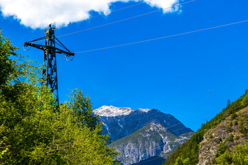 Lechtal Austria alpine mountain landscape panorama blue sky behind trees.