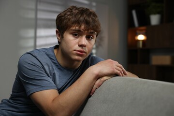 Obraz premium Teen problems. Upset teenage boy on sofa at home
