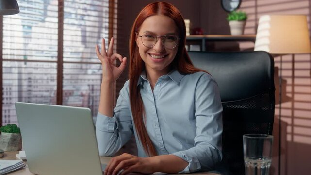 Caucasian businesswoman working laptop in office showing ok sign smiling looking at camera business woman girl female success work online job achieve demonstrate okay hand gesture entrepreneur happy