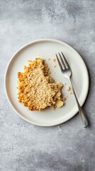 apple crumble with a moist texture, golden-brown crust, and soft interior, served in leaf decorated plate. The plate sits on a gray background. The cake has a rich apple aroma
