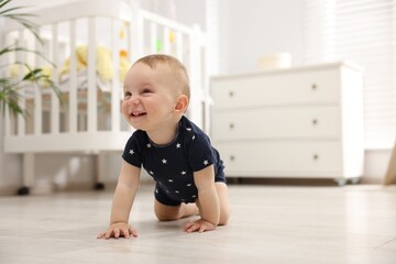 Cute little baby crawling on floor at home, space for text
